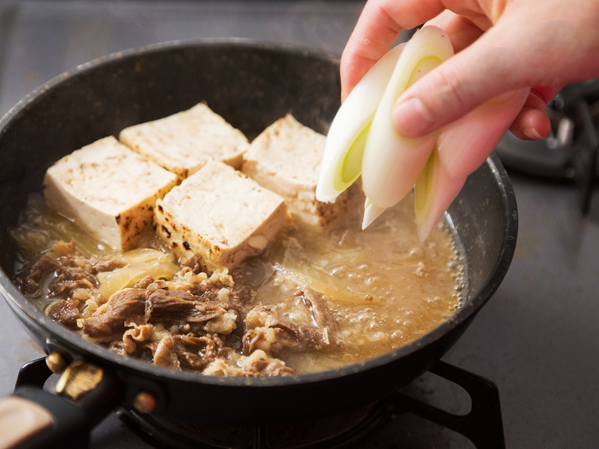 小鍋に豆腐、ねぎの順番で具を加える
