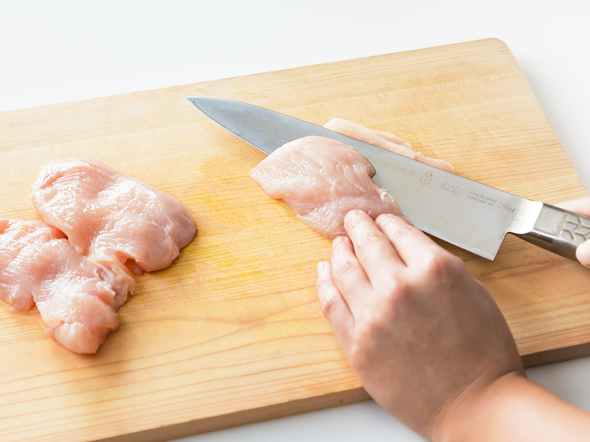 鶏胸肉は、包丁を寝かせるようにしてそぎ切りにする。