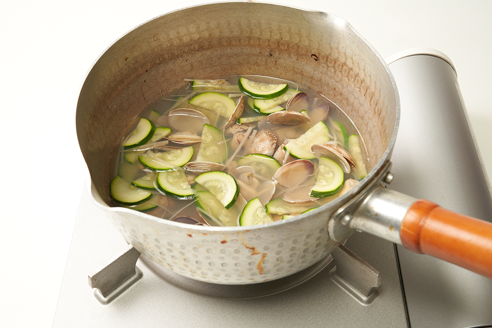 あさりで取った出汁に調味料、ズッキーニを加え、スープを作る。