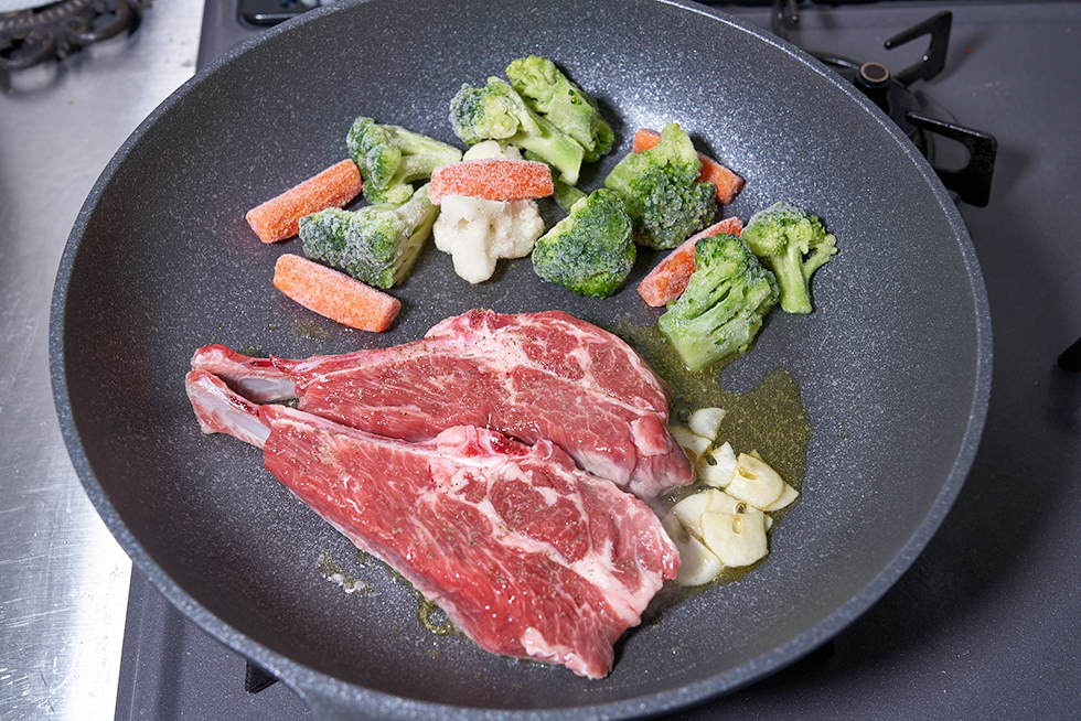 ラム肉と冷凍用野菜はフライパンの中で混ぜず、半分のスペースを使ってそれぞれを焼く。