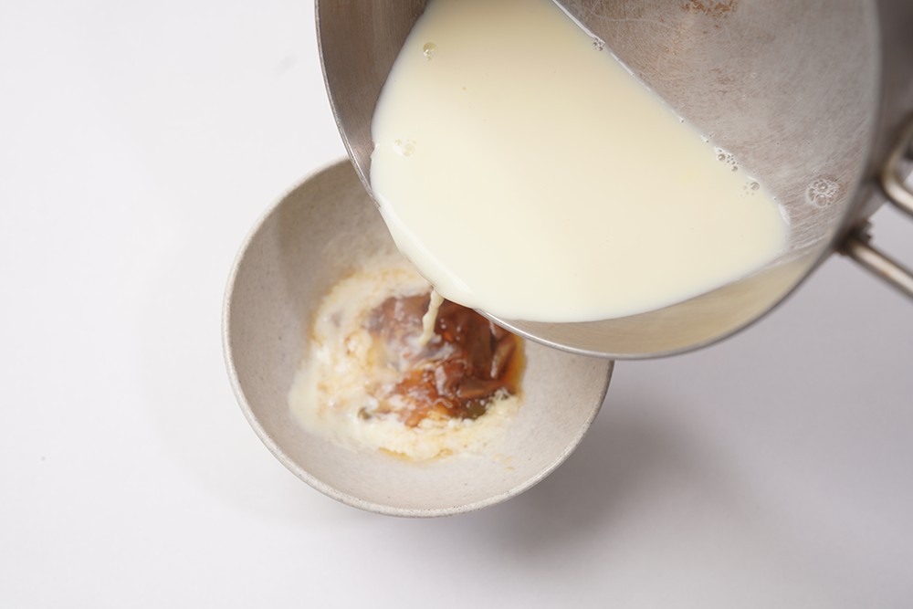 器の中にあらかじめ酢や具材を入れておき、そこに温めた豆乳を静かに注ぐ。