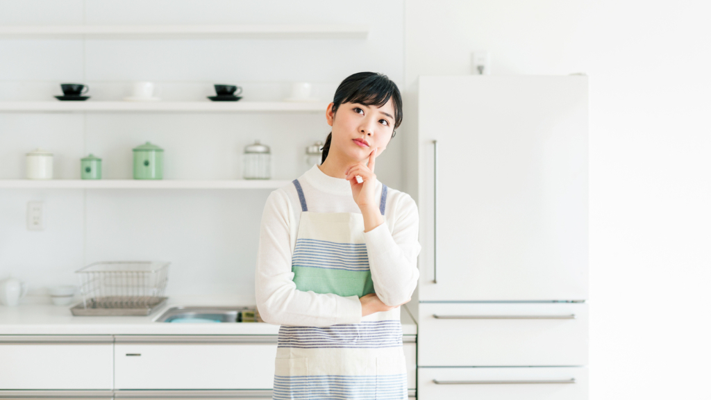 キッチンで考えている女性の画像