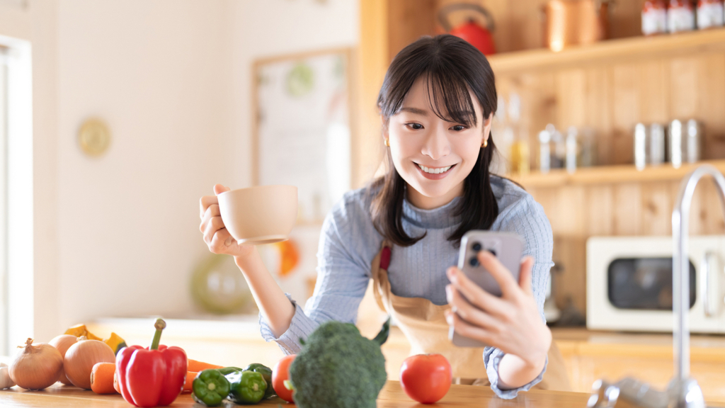 キッチンでスマホを見ている画像