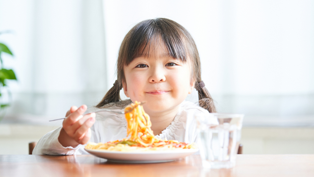 子どもがご飯を食べている画像