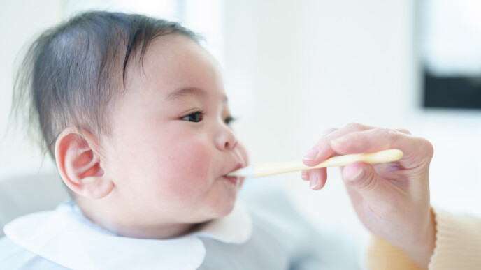 赤ちゃんに離乳食を食べさせている画像