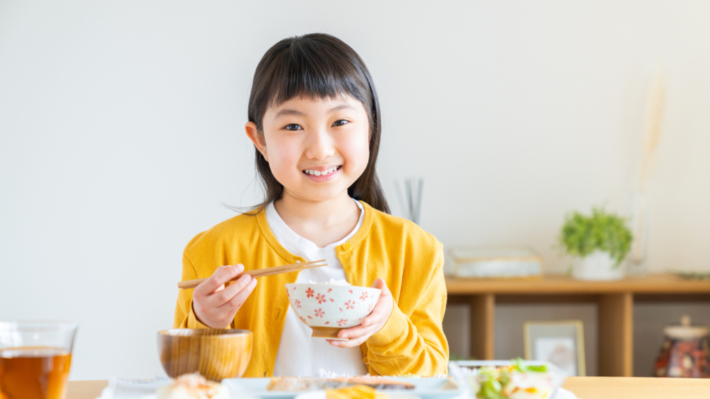 子どもがご飯を食べている画像