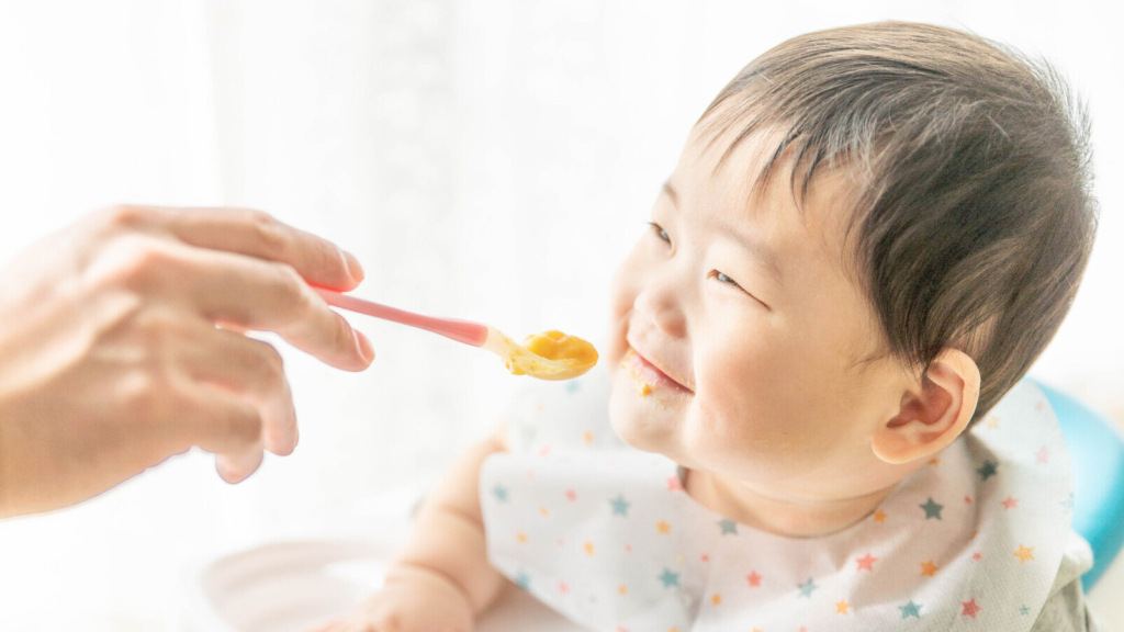 赤ちゃんに離乳食をあげている画像